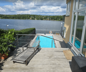 Vaierekkverk i rustfritt stål rundt treterrasse og basseng med sjøutsikt – diskret og trygt rekkverk ved høydeforskjeller.